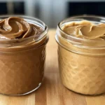 Organic peanut butter vs. regular peanut butter comparison on a wooden counter.