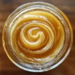 creamed honey in a glass jar on a wooden table